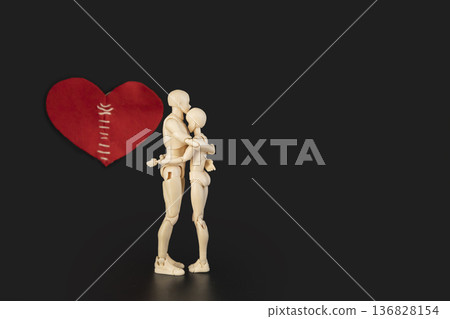 Conceptual image of two plastic mannequins hugging each other and on background a large red heart with stitches, symbolizing reconciliation, healing a broken heart, and saving a relationship Conceptual image of two plastic mannequins hugging each other and on background a large red heart with stitches, symbolizing reconciliation, healing a broken heart, and saving a relationship 136828154
