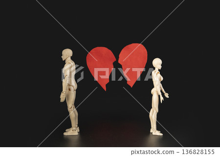 Conceptual image of two plastic mannequins go away from each other on the background two halves of a broken red heart on a black background, representing heartbreak, separation, and divorce. Conceptual image of two plastic mannequins go away from each other on the background two halves of a broken red heart on a black background, representing heartbreak, separation, and divorce. 136828155