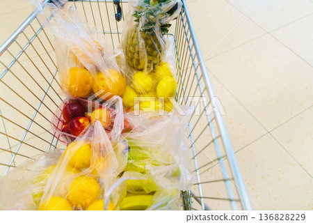 Shopping cart with grocery items at supermarket Shopping cart with grocery items at supermarket 136828229