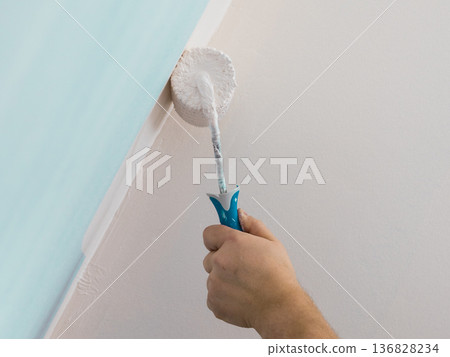 Person applying paint on wall 136828234