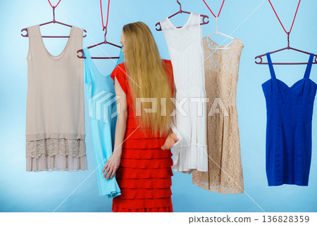 Woman choosing clothes in shop Woman choosing clothes in shop 136828359