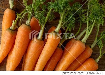 Fresh carrots with leaves (wood grain background) Fresh carrots with leaves (wood grain background) 136828639