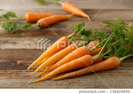 Fresh carrots with leaves (wood grain background) 136828640