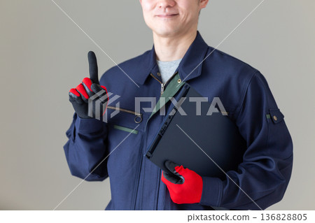 A middle-aged male businessman in work clothes holding a binder and pointing his index finger A middle-aged male businessman in work clothes holding a binder and pointing his index finger 136828805