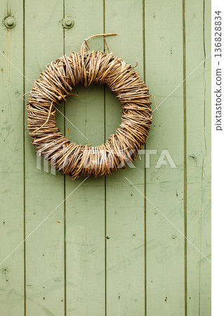 Rounded wicker decoration hanging on wooden wall Rounded wicker decoration hanging on wooden wall 136828834
