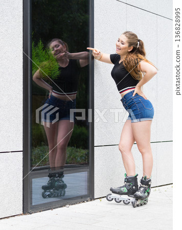 Young woman riding roller skates 136828995