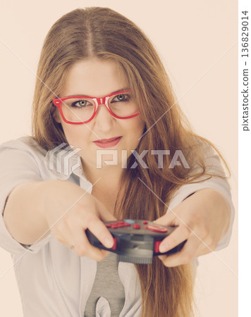 Gamer woman holding gaming pad Gamer woman holding gaming pad 136829014