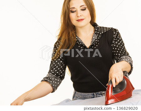 Happy woman doing ironing 136829020