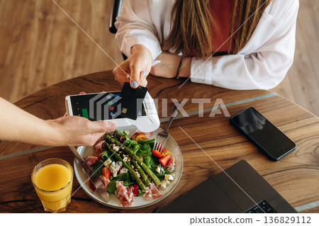 Wireless payment by using smartphone. Woman n the cafe restaurant Wireless payment by using smartphone. Woman n the cafe restaurant 136829112