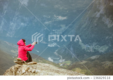 Tourist taking photo from Dalsnibba viewpoint Norway Tourist taking photo from Dalsnibba viewpoint Norway 136829118