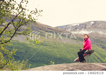 Tourist with camera looking at scenic view in mountains Norway 136829119