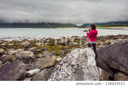 Tourist with camera on Skagsanden Beach Lofoten Norway 136829151