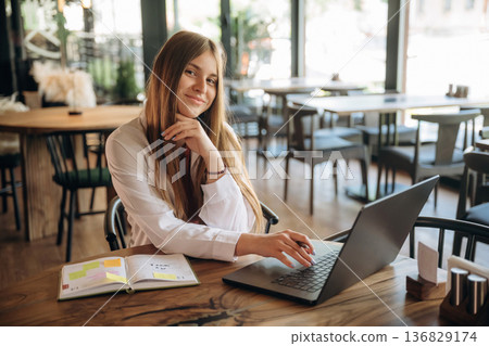 Young woman is in the cafe at daytime Young woman is in the cafe at daytime 136829174