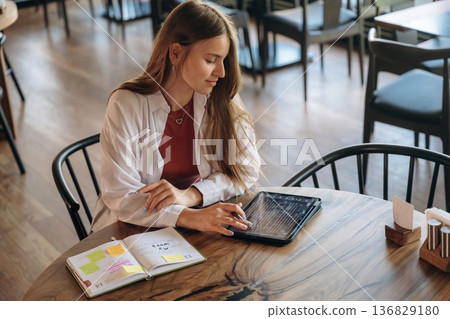 Young woman is in the cafe at daytime Young woman is in the cafe at daytime 136829180