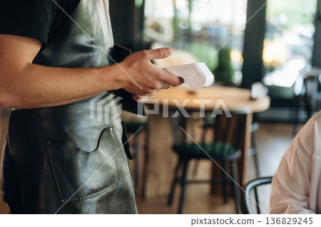 Woman is paying for meal by wireless payment in the cafe restaurant 136829245