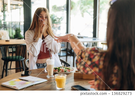 Showing ring, engaged, in shock. Two young women are together in the cafe restaurant Showing ring, engaged, in shock. Two young women are together in the cafe restaurant 136829273