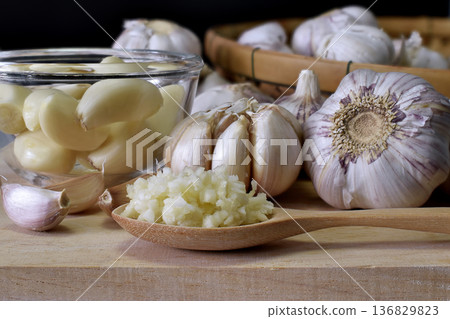 Close-up shot of minced garlic in wooden spoon placed on wooden chopping board In the kitchen prepared for food ingredients. 136829823