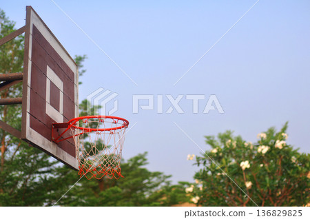 Old wooden basketball hoop has a natural background and sky. 136829825