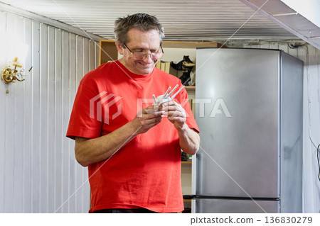 Cheerful mature man holds wifi signal repeater in his hands. Cheerful mature man holds wifi signal repeater in his hands. 136830279