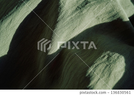 Olive green fabric texture casting shadows background 136830561