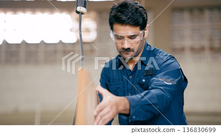 Carpenter wearing safety glasses working with wood 136830699