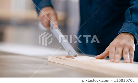 Carpenter cutting wood plank on table saw in workshop Carpenter cutting wood plank on table saw in workshop 136830703
