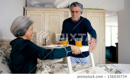 Senior man serving romantic breakfast in bed for woman 136830734