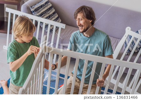 Father and older brother assembling a baby crib at home, preparing for a newborn arrival. Warm family moment full of care and anticipation. Parenthood, sibling bond and home preparation concept 136831466