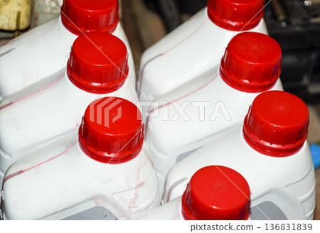 White plastic cans with red lids. Cans of transmission oil 136831839