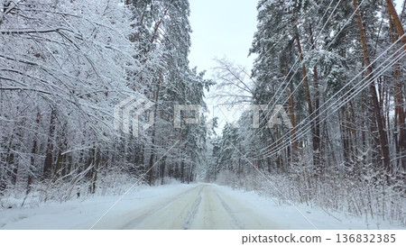 Car driving along snowy forest road in winter landscape Car driving along snowy forest road in winter landscape 136832385