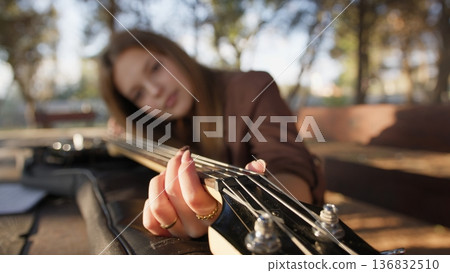 Girl Plays Bass Musical Instrument Resting On Table In Mountains 136832510