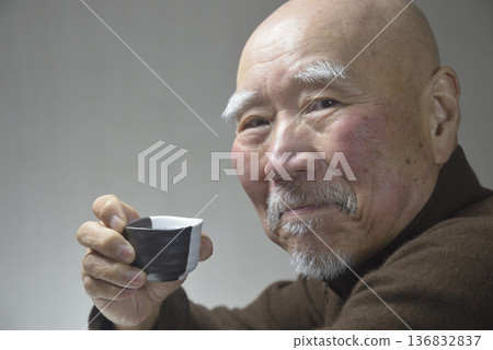 An elderly man drinking sake with a smile An elderly man drinking sake with a smile 136832837