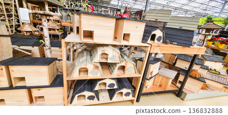 Berlin, Germany - August 06, 2025: Wooden birdhouses displayed on shelves in garden center for outdoor decor Berlin, Germany - August 06, 2025: Wooden birdhouses displayed on shelves in garden center for outdoor decor 136832888
