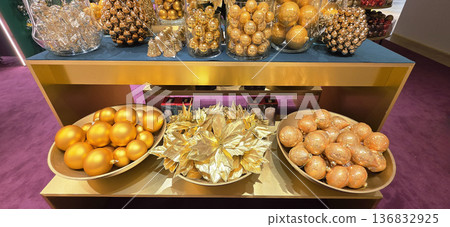 Berlin, Germany - September 19, 2025: Golden holiday decorations displayed on elegant table in festive setting Berlin, Germany - September 19, 2025: Golden holiday decorations displayed on elegant table in festive setting 136832925