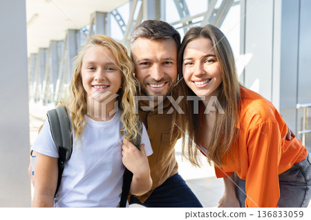 Close portrait of smiling caucasian family at airport terminal, daughter with backpack 136833059