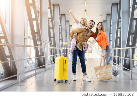 Family at airport enjoying vacation trip with luggage in bright modern terminal Family at airport enjoying vacation trip with luggage in bright modern terminal 136833108