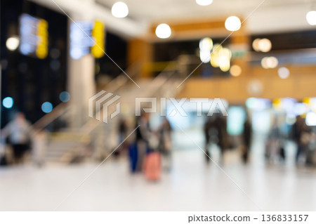 Blurred airport terminal interior with travelers and departure boards Blurred airport terminal interior with travelers and departure boards 136833157