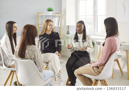 Group sitting in circle, women engaged in group discussion, speaking, listening attentively, sharing Group sitting in circle, women engaged in group discussion, speaking, listening attentively, sharing 136833517