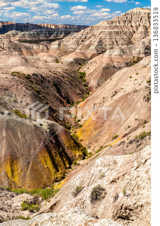 Scenic landscape view of the colorful sedimentary rock layers and rugged terrain at the Yellow Mounds area in Badlands National Park, South Dakota, United States Scenic landscape view of the colorful sedimentary rock layers and rugged terrain at the Yellow Mounds area in Badlands National Park, South Dakota, United States 136833519