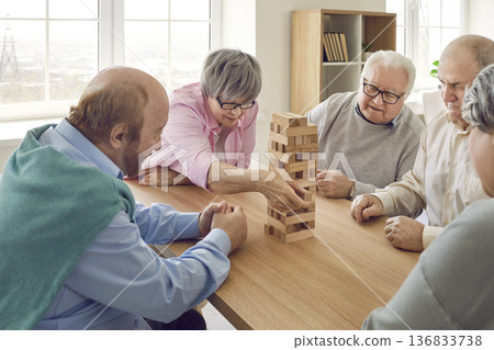 Group of seniors playing together with wooden building blocks for dementia therapy in nursing home. Group of seniors playing together with wooden building blocks for dementia therapy in nursing home. 136833738