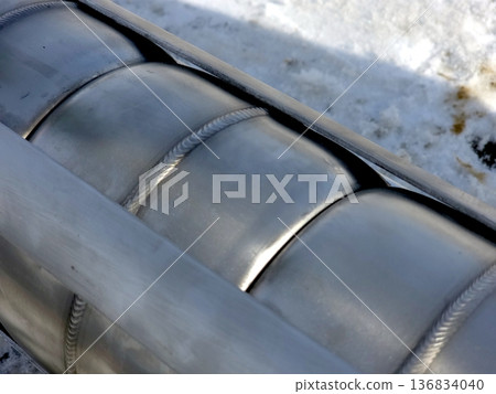 Stainless Steel Artesian Pump Housing Details Shown Against a Snowy Background 136834040
