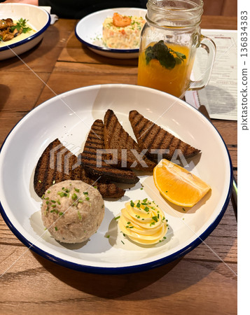 Forshmak fish appetizer with bread slices, butter and lemon on a plate at restaurant close up. Famous dish at Jewish cuisine based on chopped herring. 136834383