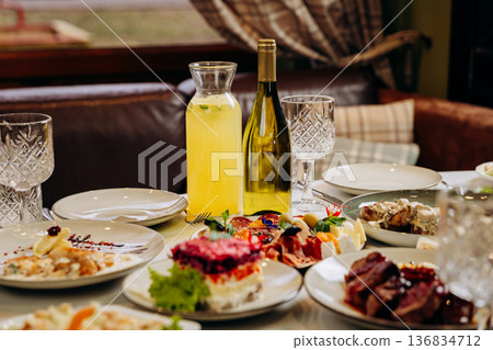 Festive restaurant table with gourmet dishes, wine and drinks ready for celebration Festive restaurant table with gourmet dishes, wine and drinks ready for celebration 136834712