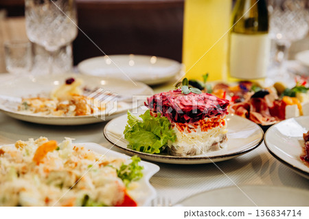 Traditional layered herring salad served on festive restaurant dinner table Traditional layered herring salad served on festive restaurant dinner table 136834714