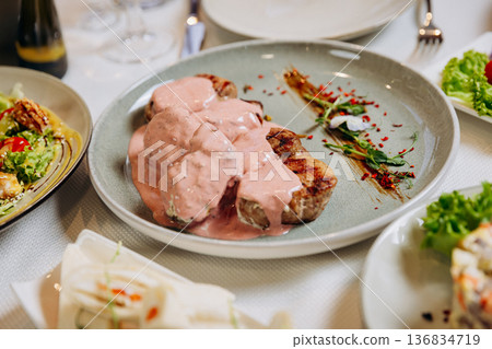 Grilled meat medallions with creamy sauce served on elegant restaurant dinner table Grilled meat medallions with creamy sauce served on elegant restaurant dinner table 136834719