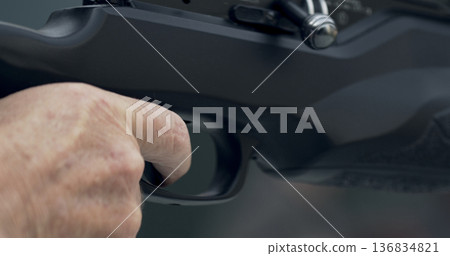 Person prepares to shoot a firearm in a controlled setting during a training session at a shooting range 136834821