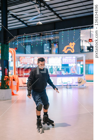 Happy Adult Man Enjoying Rollerblading in an Indoor Rink 136834896