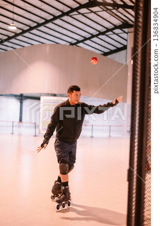 Adult Man Inline Skating and Catching Ball Indoors Adult Man Inline Skating and Catching Ball Indoors 136834904