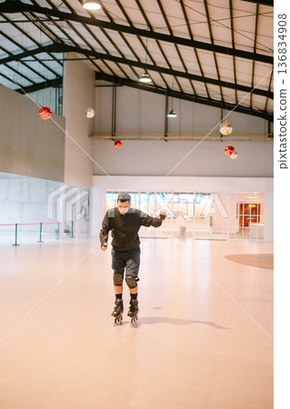 Adult Man Rollerblading in Spacious Modern Indoor Hall 136834908