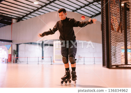 Concentrated Man Practicing Inline Skating Indoors with Focus Concentrated Man Practicing Inline Skating Indoors with Focus 136834962
